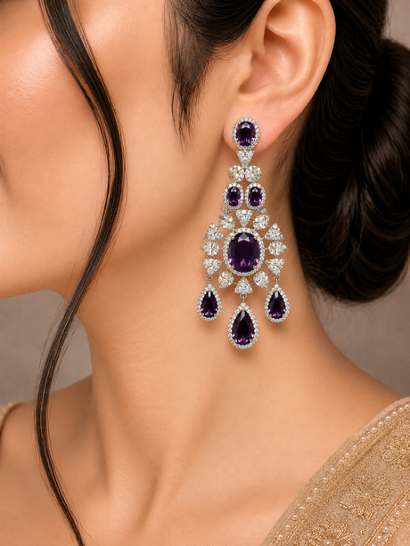 Close-up of a woman wearing a pair of purple gemstone earrings with a neutral background
