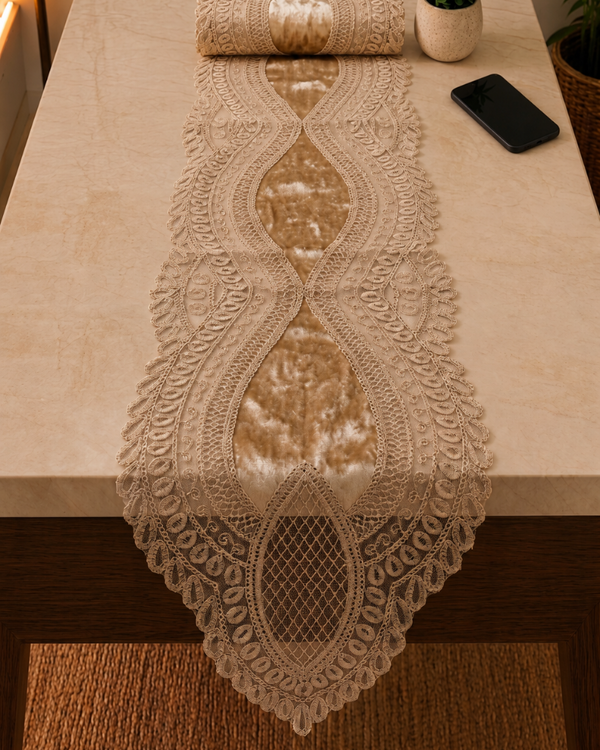 A beige lace table runner with a central satin stripe is draped over a light stone table, with a matching runner roll at the top and a smartphone nearby.