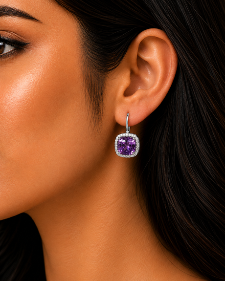 Close-up of a woman's ear wearing a purple gemstone earring.