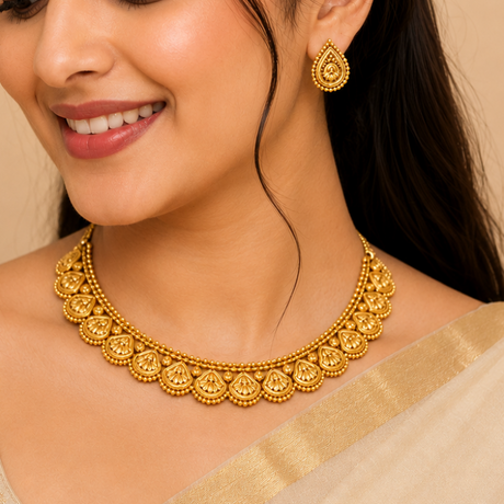 Woman wearing gold jewelry including a necklace and earrings against a beige background