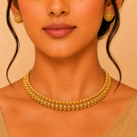 Close-up of a woman wearing a gold necklace and earrings against a beige background