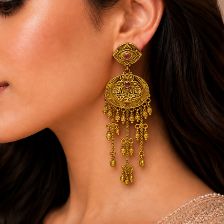 Close-up of a woman wearing a gold earring with intricate designs.