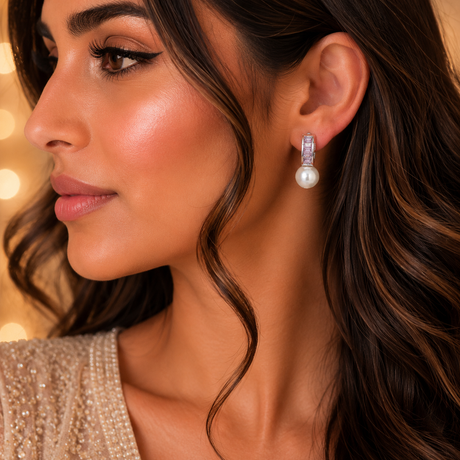 Close-up of a woman wearing pearl earrings with a blurred background
