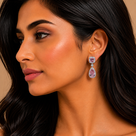 Close-up of a woman wearing a pair of earrings with a beige background