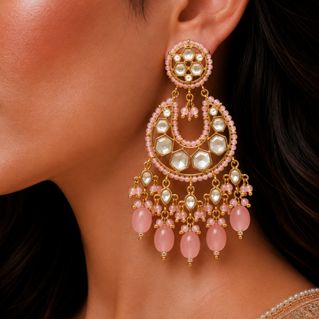 Close-up of a woman wearing a pair of pink and gold earrings.