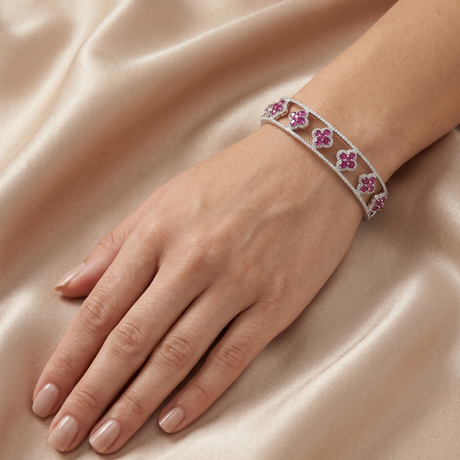 Bracelet with pink gemstones on a hand against a satin background