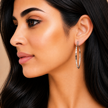 Close-up of a woman wearing hoop earrings with a neutral background