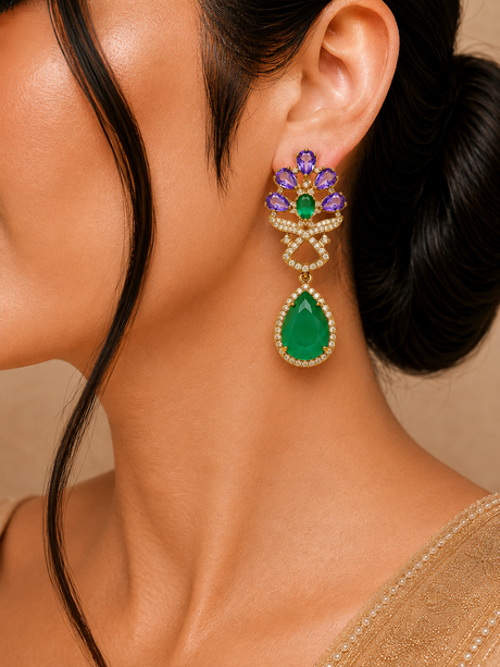 Close-up of a woman wearing a green teardrop earring with purple and gold accents.