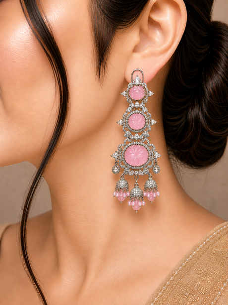 Close-up of a woman wearing a pink gemstone earring with silver accents.