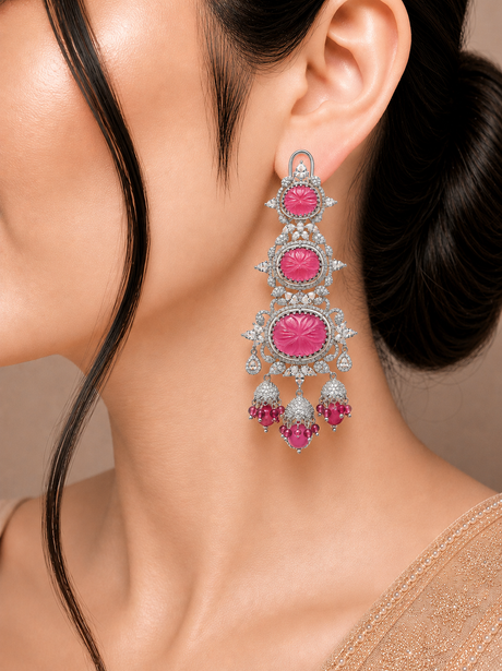 Close-up of a woman wearing an ornate earring with pink gemstones.