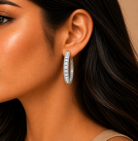 Close-up of a woman wearing a silver hoop earring with a neutral background