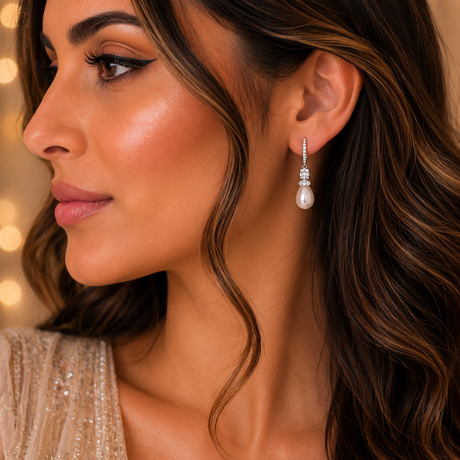 Close-up of a woman wearing pearl earrings with a blurred background