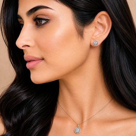 Close-up of a woman wearing diamond earrings and necklace against a neutral background