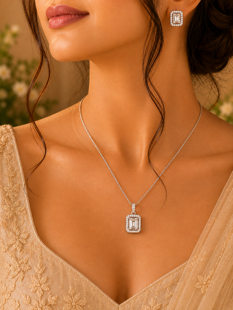 Close-up of a woman wearing a silver necklace with a diamond pendant and matching earrings.