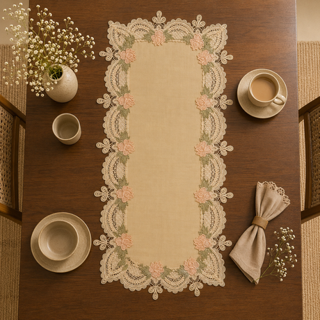 Decorative lace table runner on a wooden table with cups and a napkin.