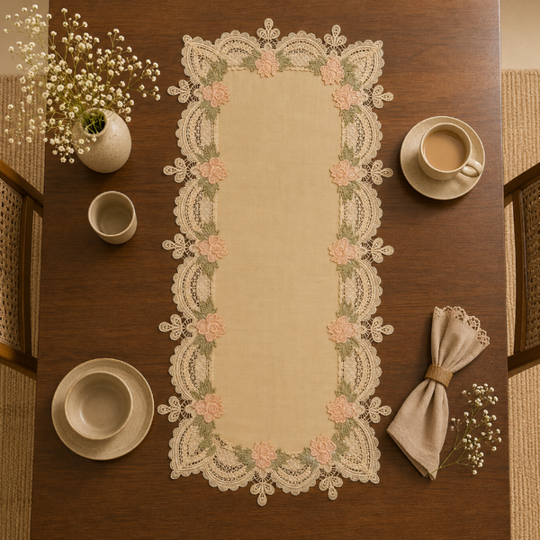 Decorative lace table runner on a wooden table with cups and a napkin.
