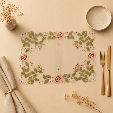 Decorative placemat with floral design on a beige surface with cutlery and napkins.