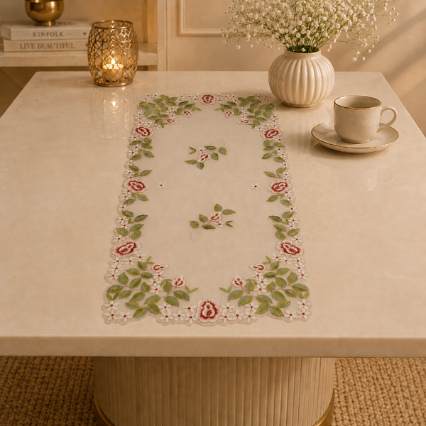 Decorative table runner with floral pattern on a table with a cup and saucer.