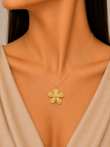 Gold flower necklace on a model with a neutral background