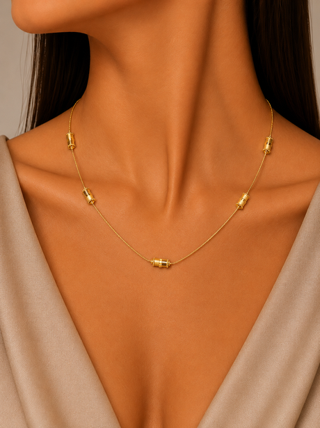 Gold necklace on a model with a neutral background