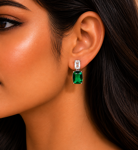 Close-up of a woman wearing emerald green earrings with a blurred background