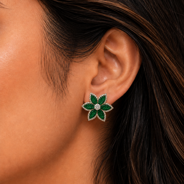 Close-up of a woman's ear wearing a green and silver floral earring.
