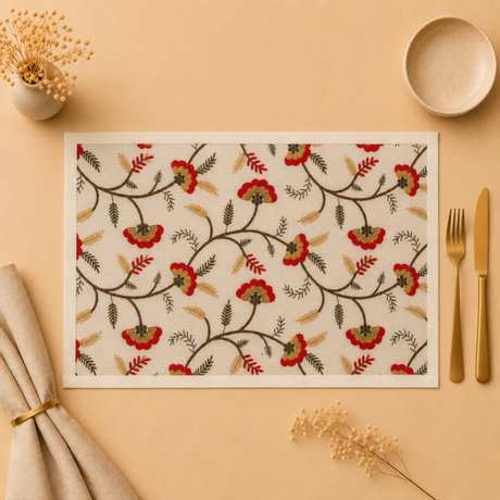 Floral patterned placemat on a beige surface with cutlery and decor items.