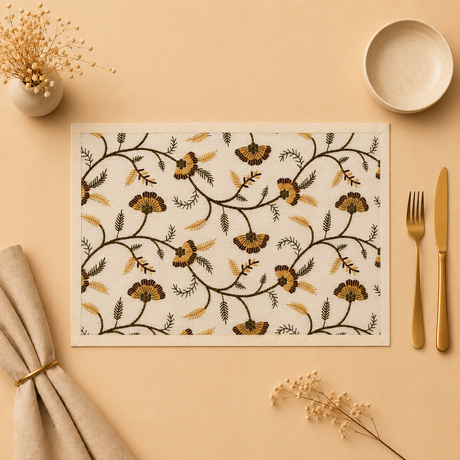 Floral-patterned placemat on a beige surface with cutlery and decor items.
