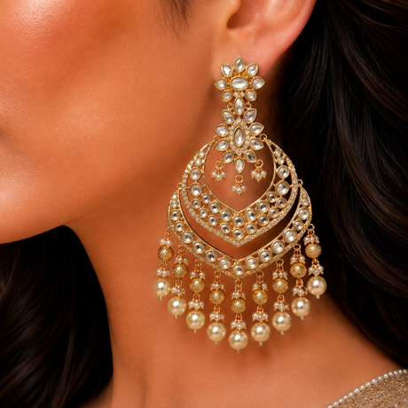 Close-up of a woman wearing a gold and pearl earring.
