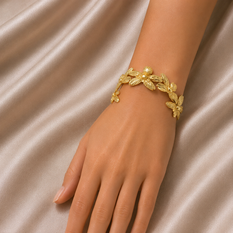 Gold bracelet on a hand against a satin background