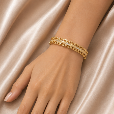 Gold bracelet on a hand against a satin background