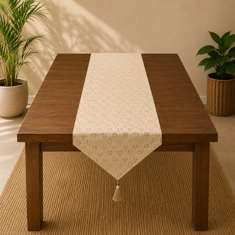 Wooden table with a beige patterned table runner in a room with plants.