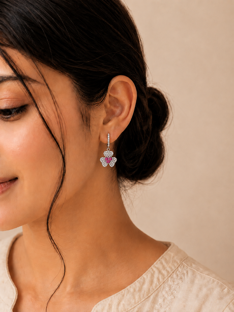 Close-up of a woman wearing a pair of earrings with a neutral background