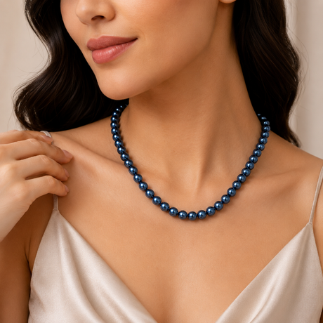 Woman wearing a blue pearl necklace against a neutral background