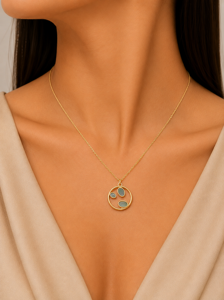 Necklace with a circular pendant featuring three colored stones worn by a model.