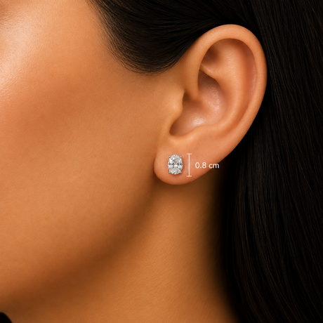 Close-up of a model's ear wearing a small oval stud earring, with a measurement marker indicating 0.8 cm size.