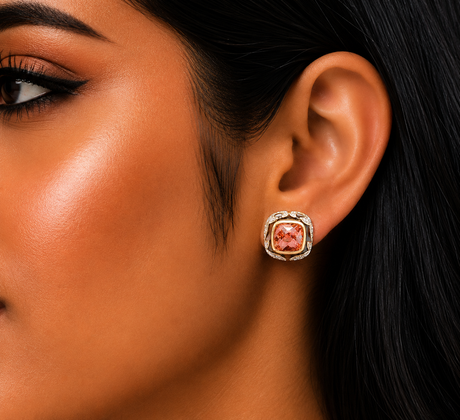 Close-up of a woman's ear wearing a pink gemstone earring.