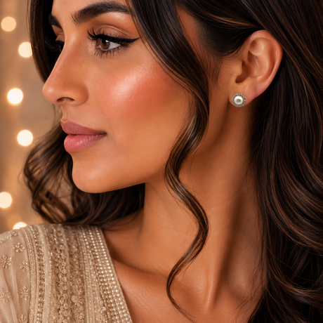 Close-up of a woman wearing pearl earrings with a blurred background