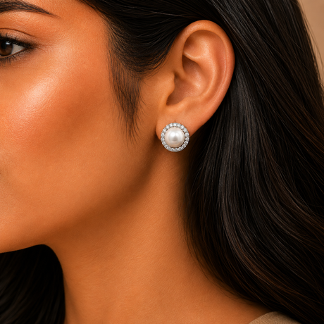 Close-up of a woman wearing pearl earrings with a neutral background