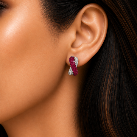 Close-up of a woman's ear wearing a silver and red hoop earring.