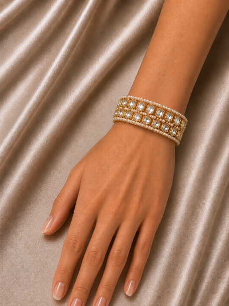 Hand wearing a beaded bracelet on a satin background