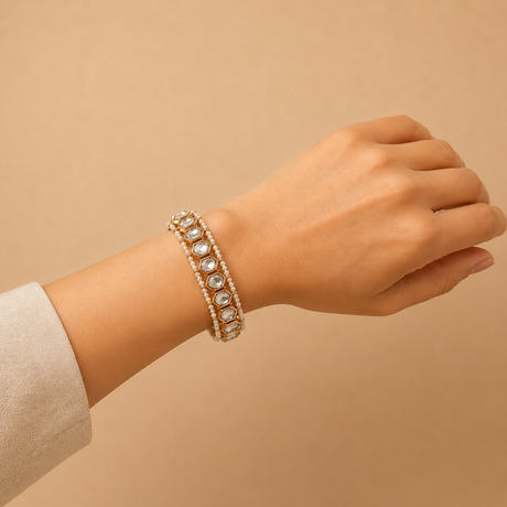 Hand wearing a bracelet on a beige background