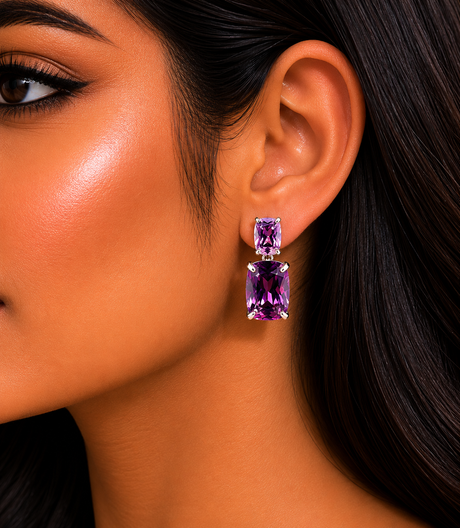 Close-up of a woman wearing purple gemstone earrings with a blurred background