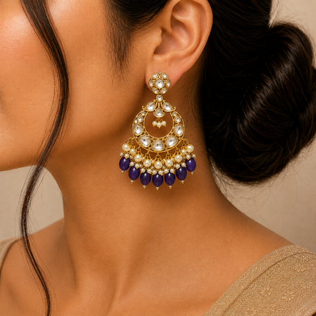 Close-up of a woman wearing a gold earring with blue and white beads.