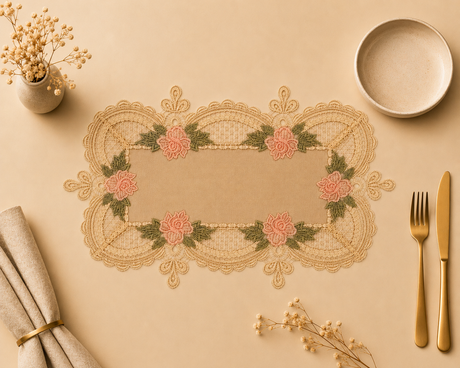Decorative lace table mat with floral patterns on a beige surface with cutlery and flowers.