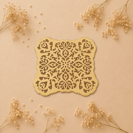 Decorative laser-cut paper with intricate patterns on a beige background with dried flowers.