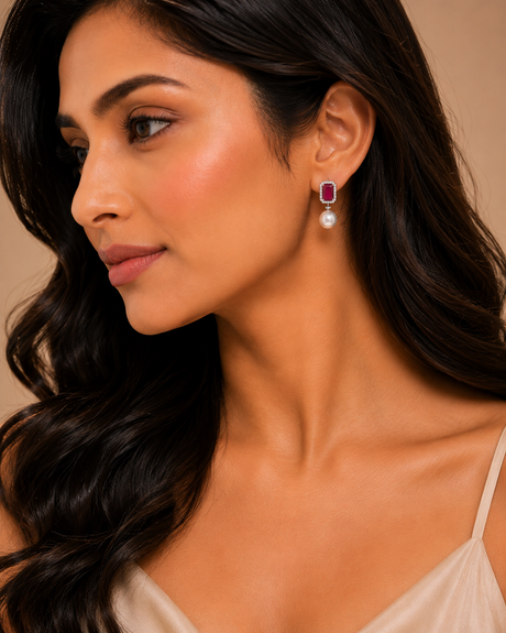 Woman wearing a pair of earrings with a neutral background