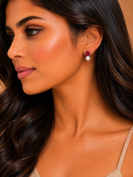 Close-up of a woman wearing earrings with a neutral background