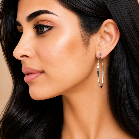 Close-up of a woman wearing hoop earrings with a neutral background