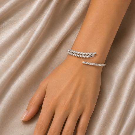 Silver bracelet on a hand against a beige fabric background